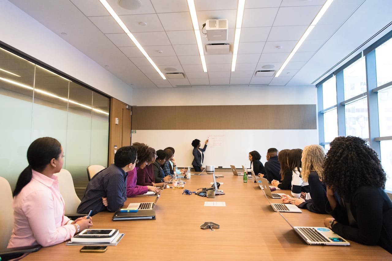 A meeting room with colleagues gathered around a long table
